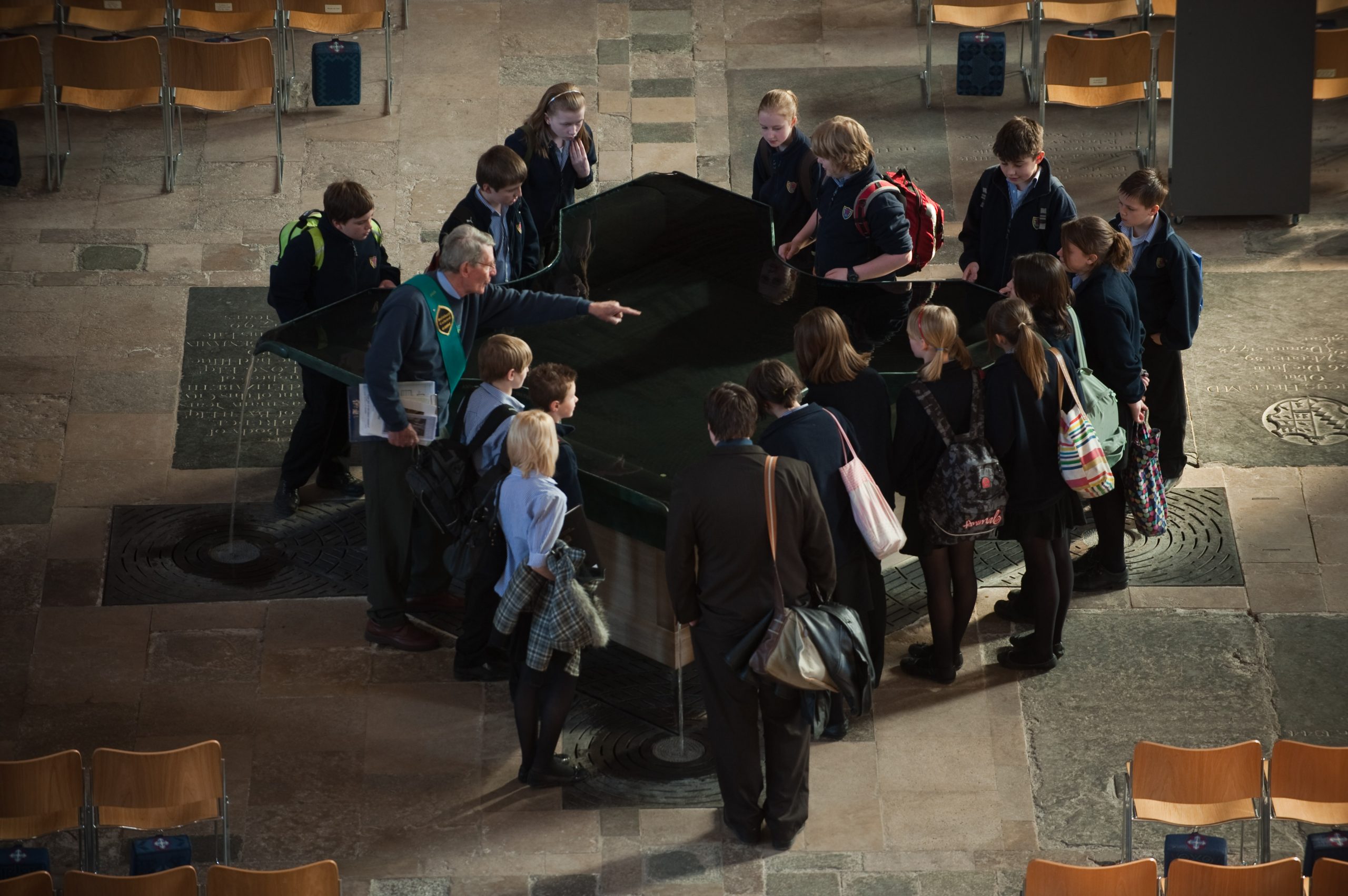 Children Visiting Salisbury Cathedral, looking into the reflective font.
