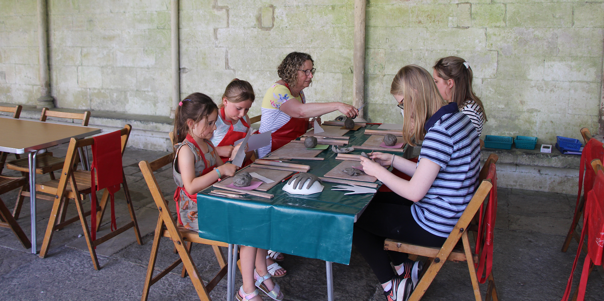 Children and adults sat around a table, taking part in a clay activity