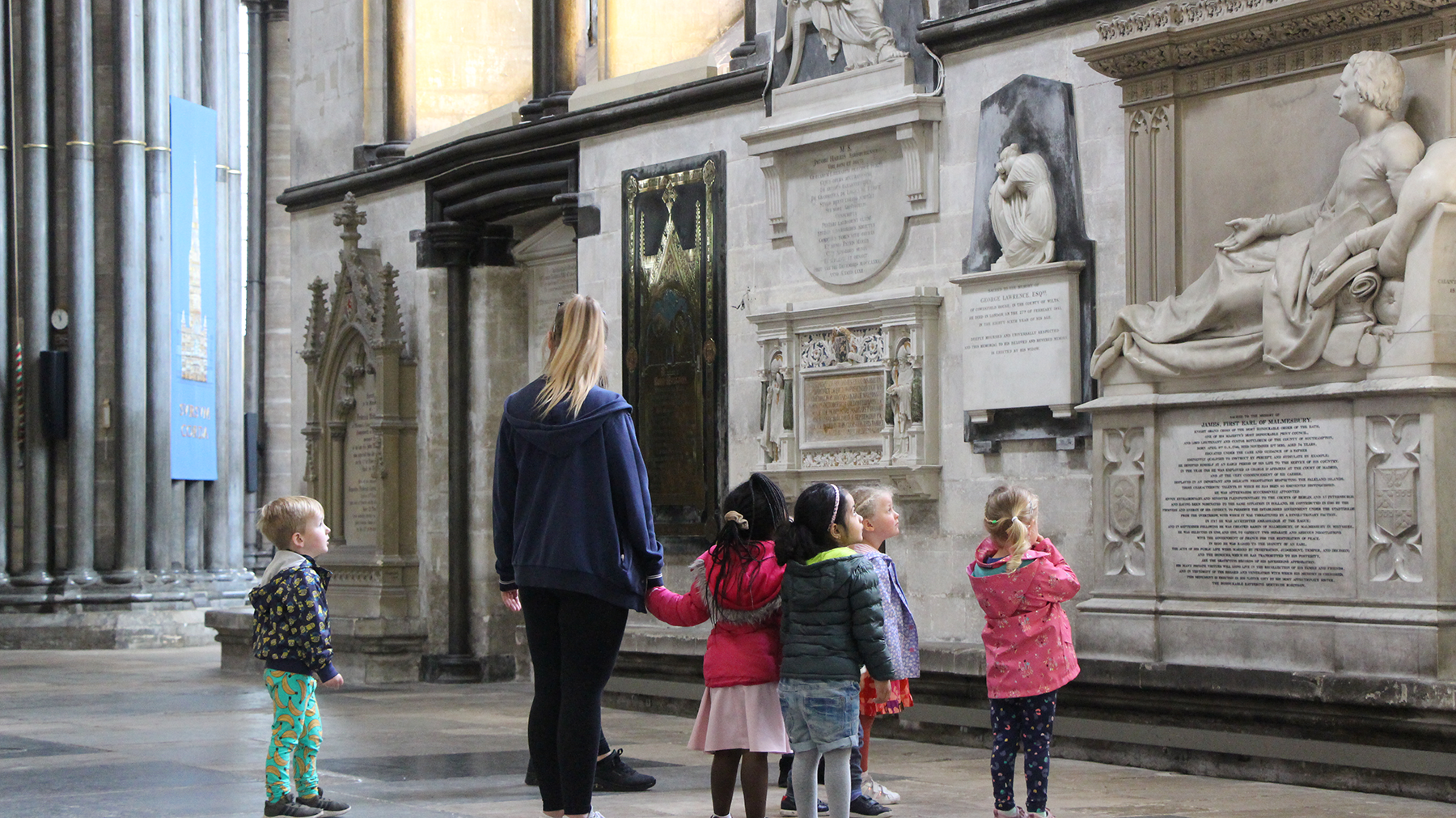One adult with five young children inside Salisbury Cathedral