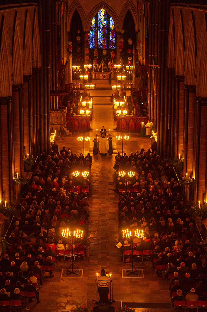 Aerial view of full congregation in a Cathedral lit by candlelight