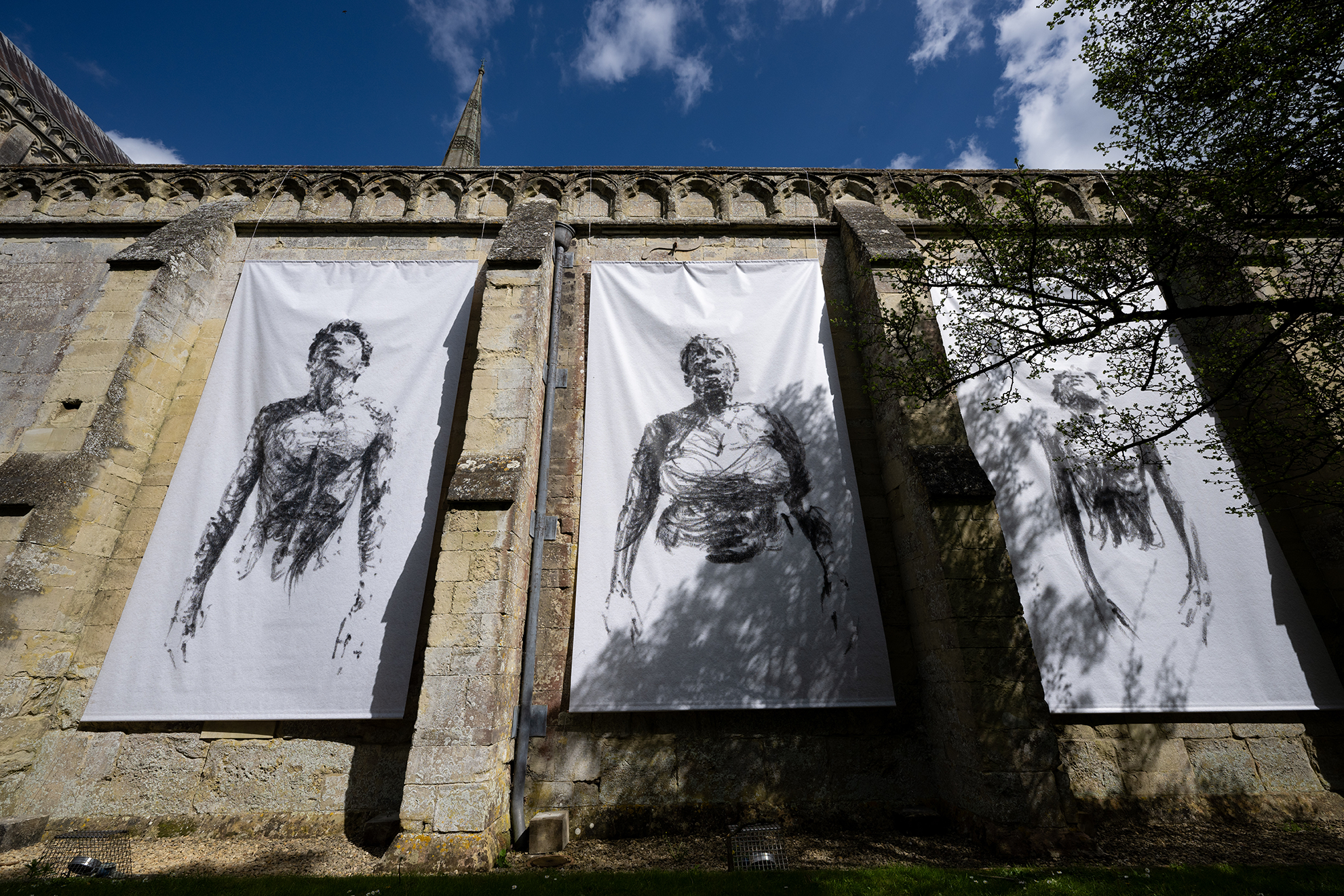 Breathe by Dryden Goodwin, three banners hanging on the walls on Salisbury Cathedral depicting people breathing
