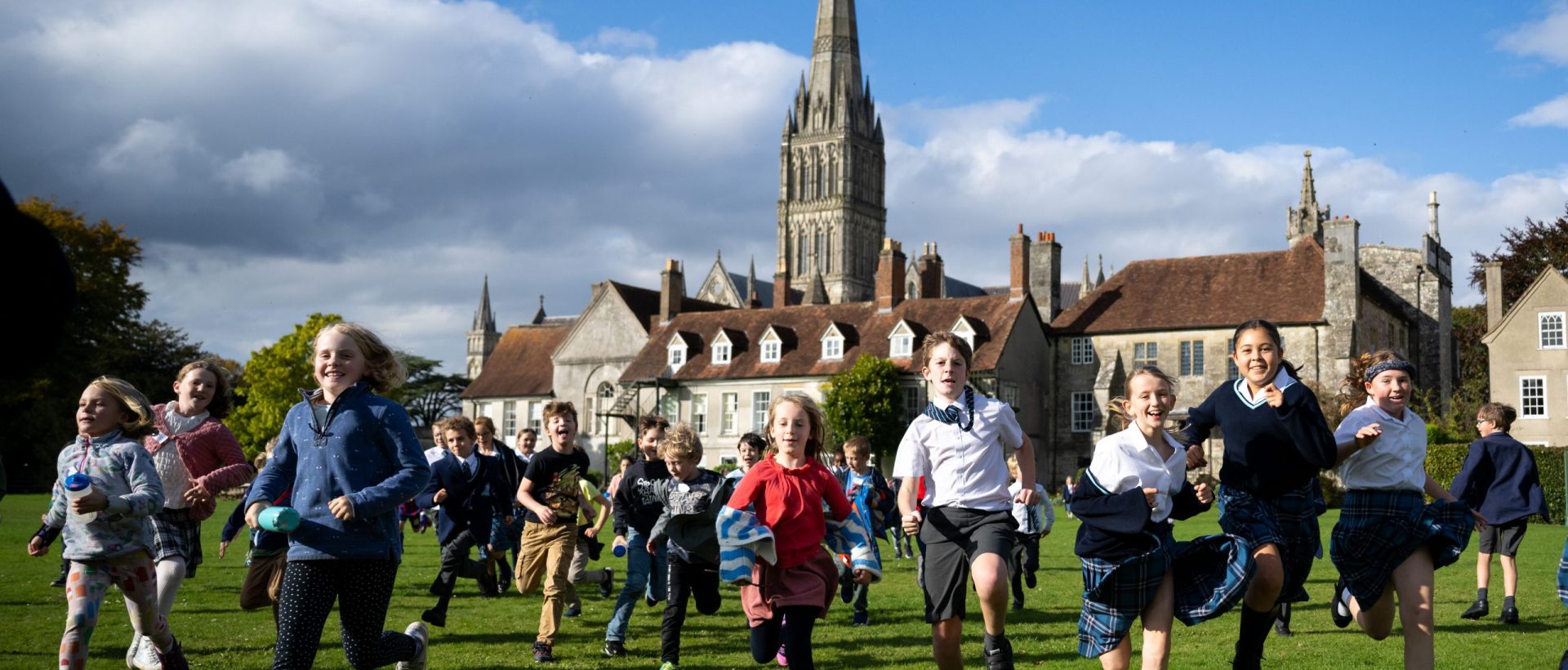 Group of young children running across the lawn