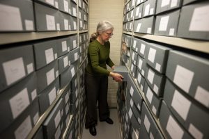 Archivist Emily Naish removing a box from the archive shelves