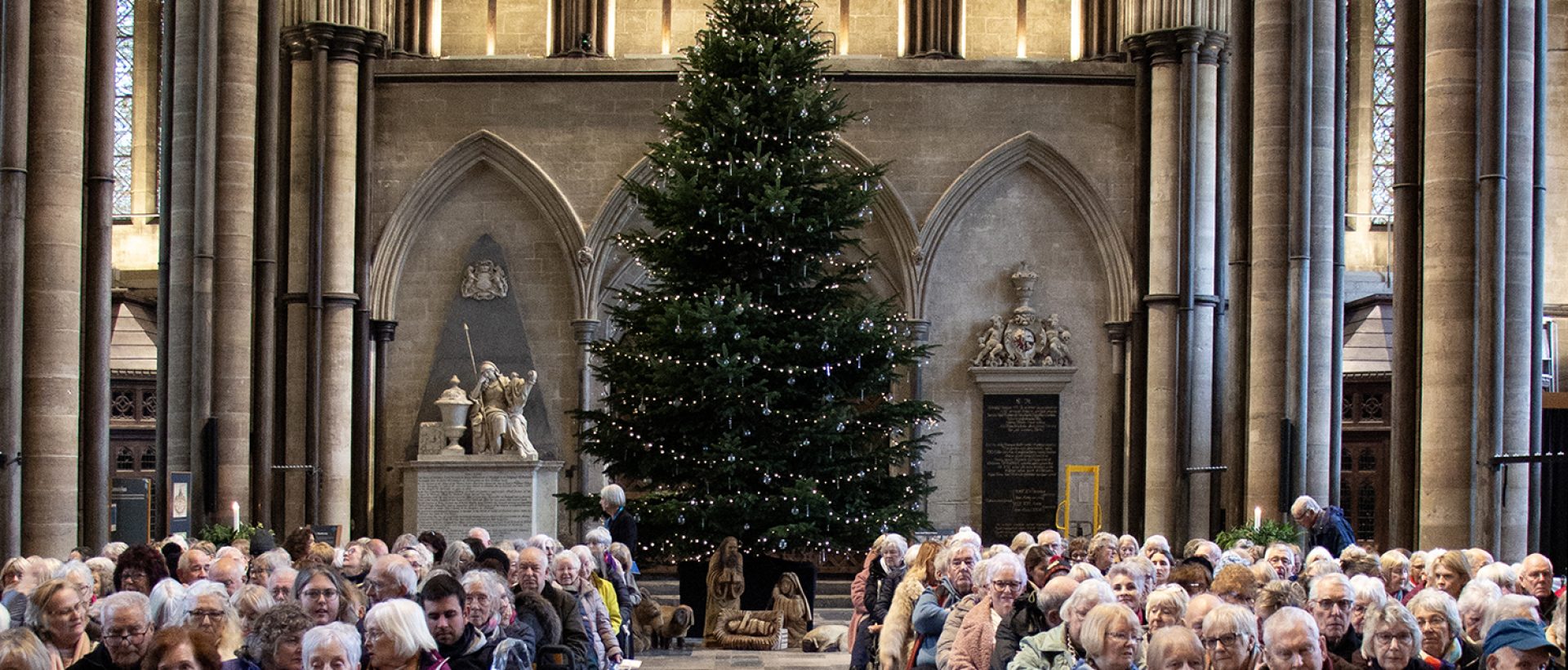 Cathedral nave looking west, with christmas tree and reflecting font, filled with worshippers