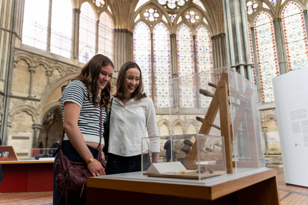 Two young women enjoy looking at a display in the Chapter House