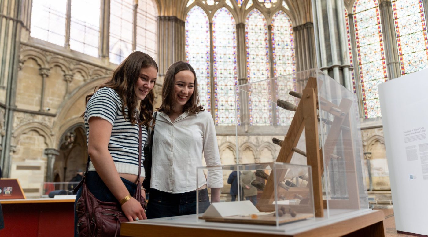 Two young women enjoy looking at a display in the Chapter House