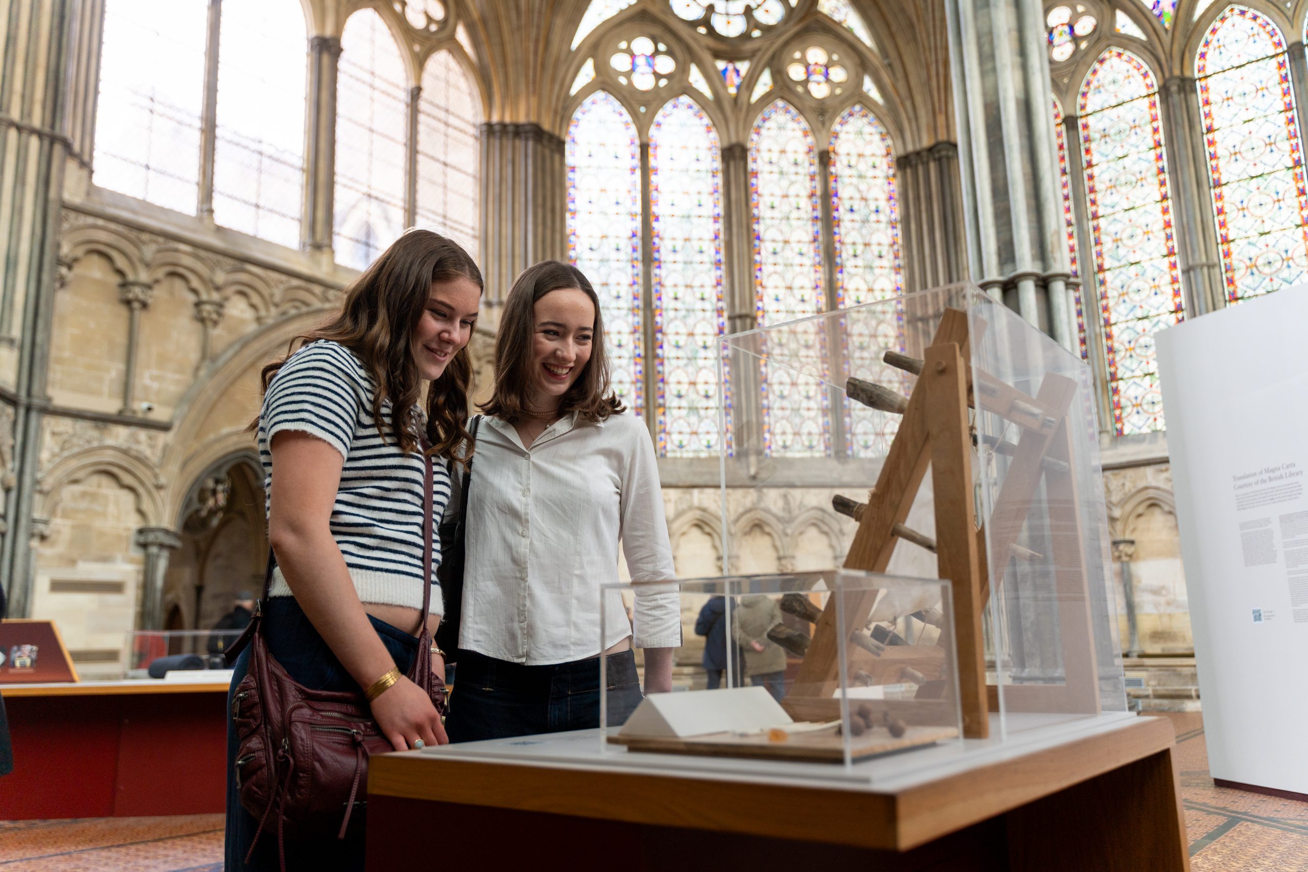 Two young women enjoy looking at a display in the Chapter House
