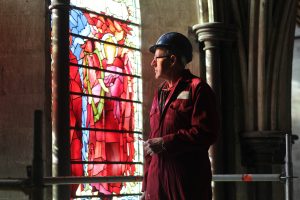 Head Glazier, Sam Kelly, examines the Burne Jones window prior to removal for conservation.